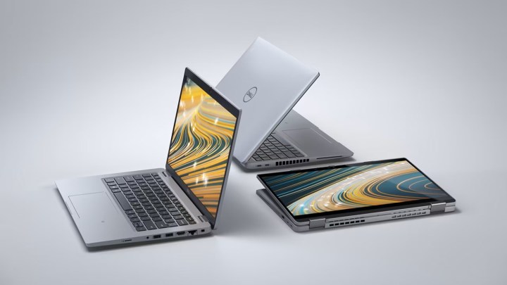 Dell laptops laid out against a gradient background.
