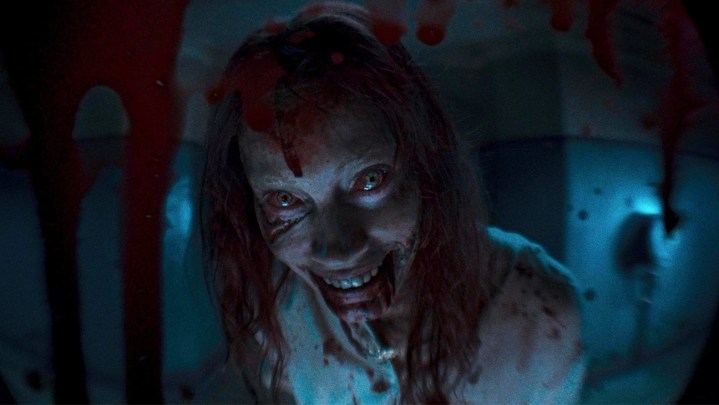 A zombie looks in a peep hole in Evil Dead Rise.