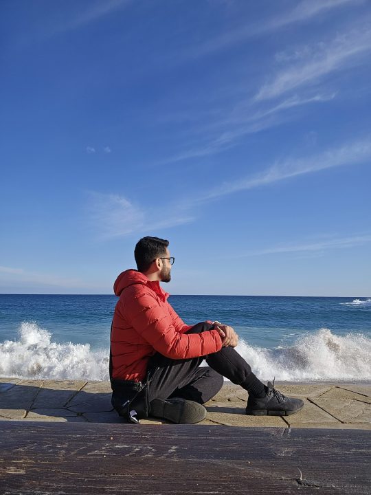 Prakhar Khanna seduto sulla spiaggia della Costa Brava.