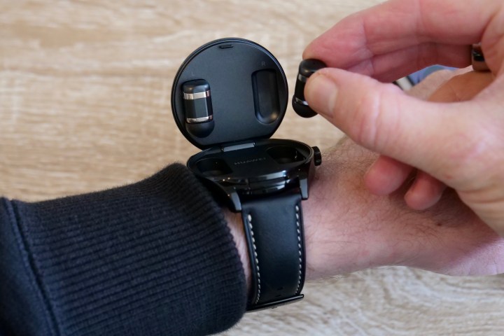 A person taking out the Huawei Watch Buds's earbuds.