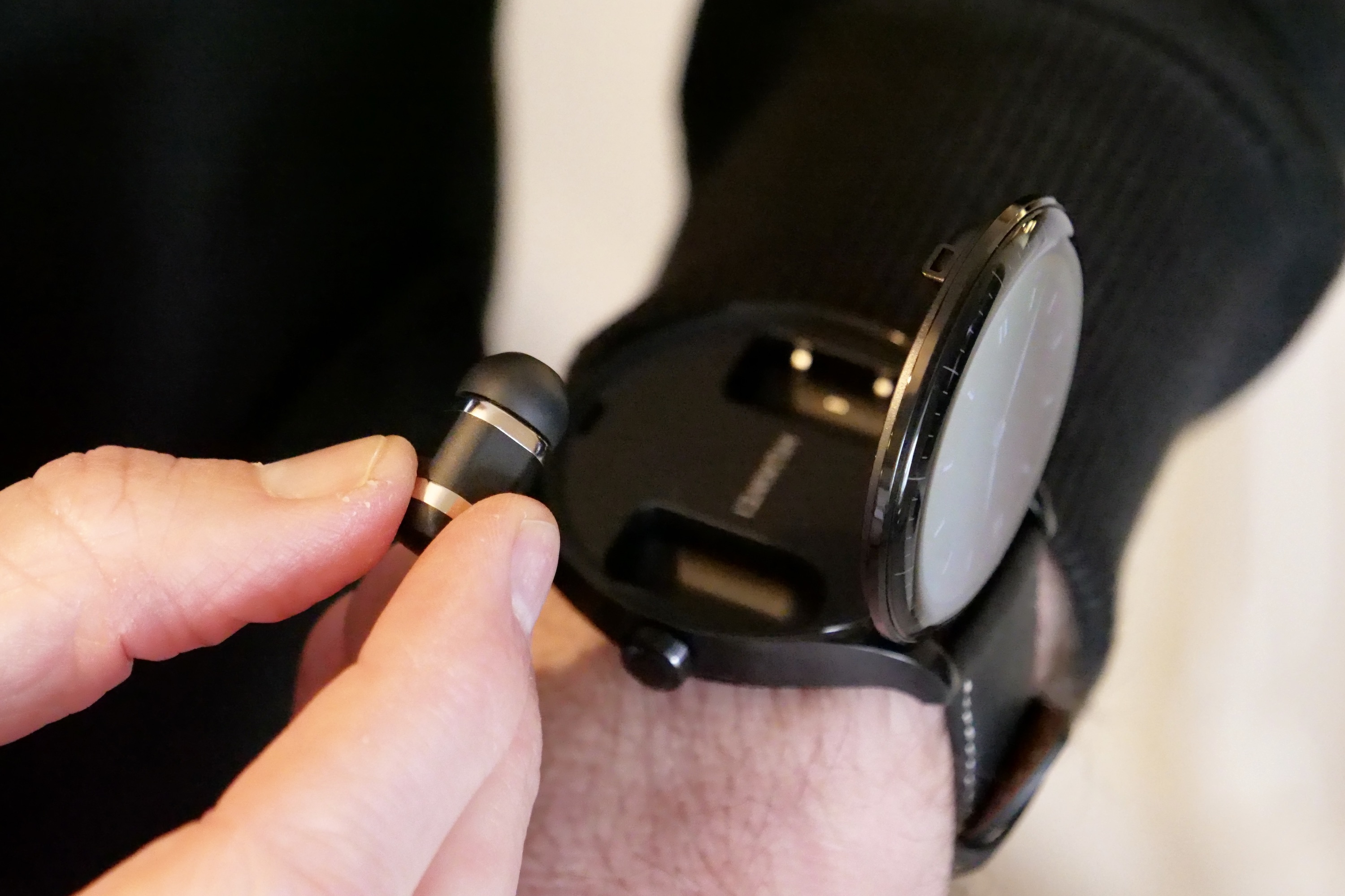 A person taking out one of the Huawei Watch Buds's earbuds.