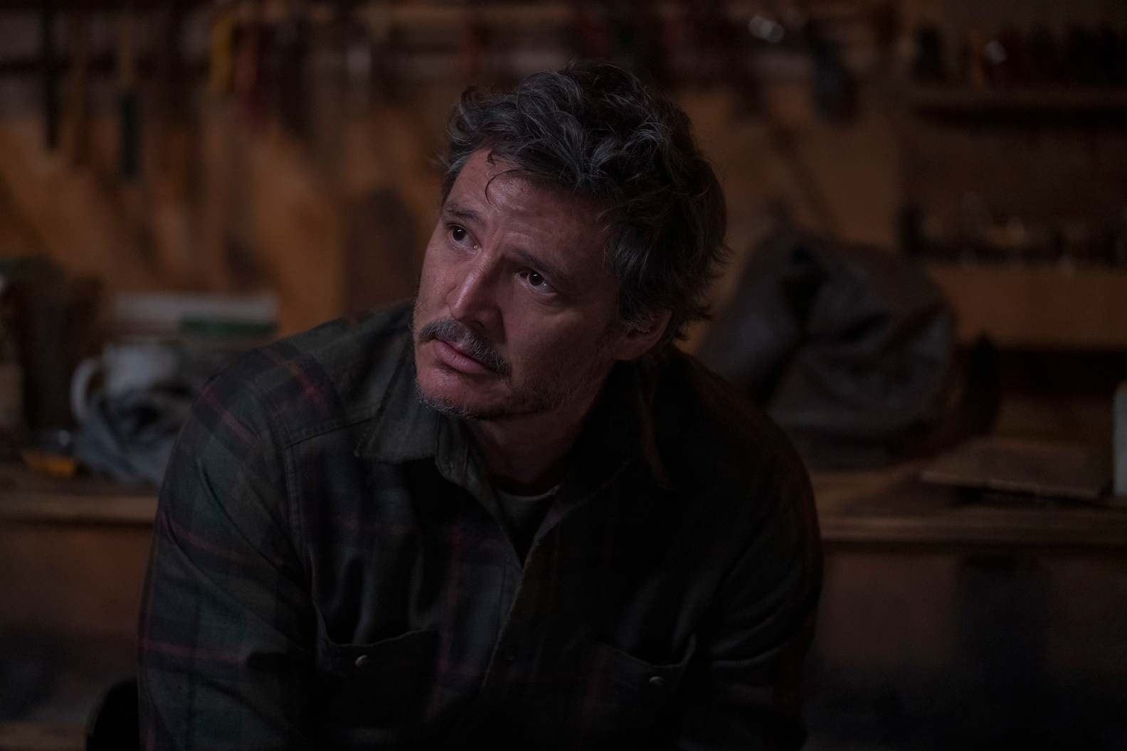 Joel está sentado em uma marcenaria no episódio 6 de The Last of Us.