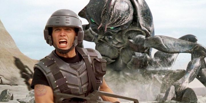 Johnny runs from a giant alien bug in Starship Troopers