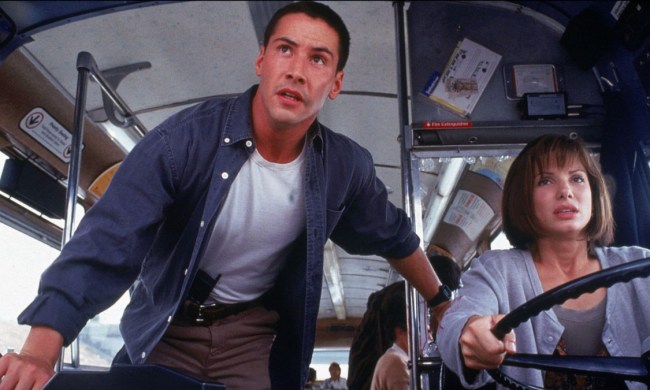 Keanu Reeves stands next to a bus driver in Speed.
