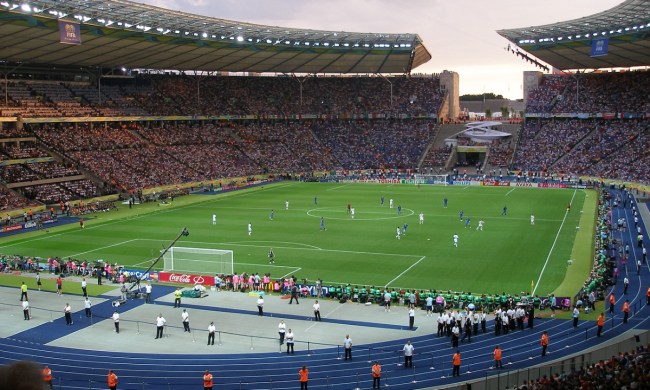 Massive open air soccer stadium with a game in play.