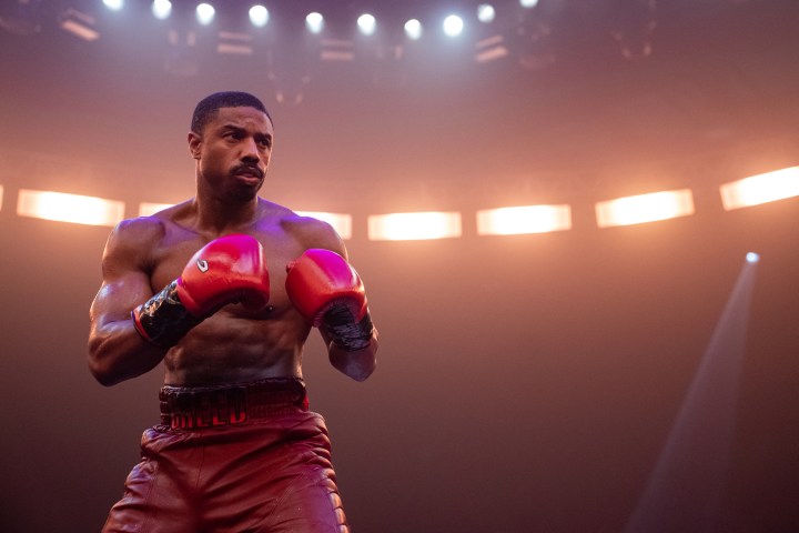 Michael B. Jordan wears red boxing gloves and trunks in Creed 3.