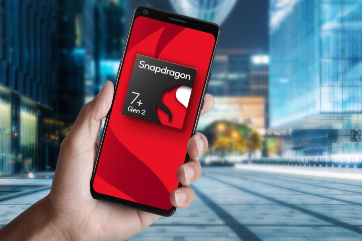 Mano sosteniendo un teléfono inteligente contra un fondo de ciudad con el logotipo de Qualcomm Snapdragon7 + Gen 2.