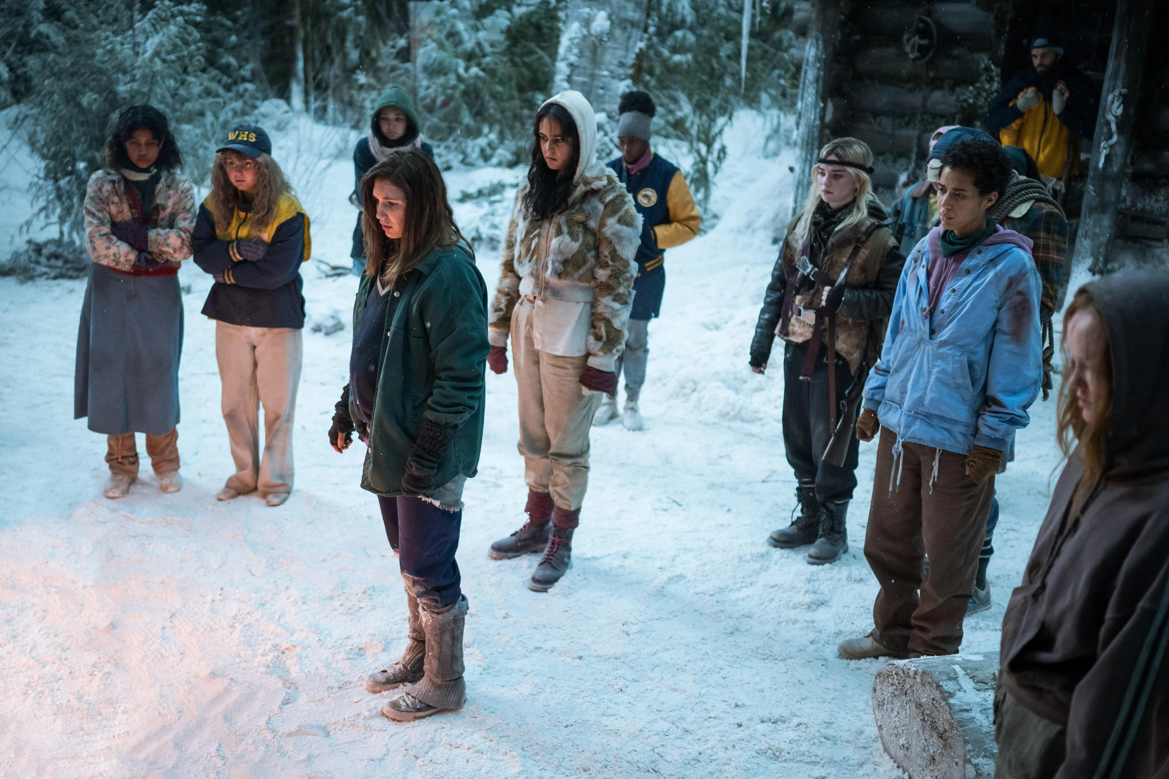Os adolescentes dos Yellowjackets ficam do lado de fora na neve juntos na 2ª temporada dos Yellowjackets.