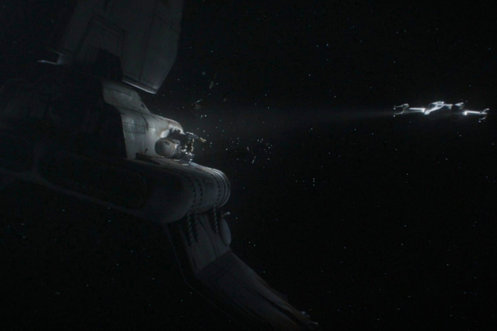 Um X-Wing ilumina uma nave imperial de transporte de prisioneiros destruída no episódio 5 da 3ª temporada de The Mandalorian.
