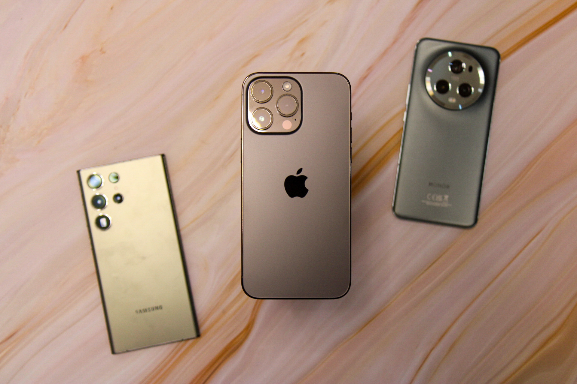 iPhone 14 Pro Max no meio com Galaxy S23 Ultra à esquerda e Honor Magic 5 Pro à direita.