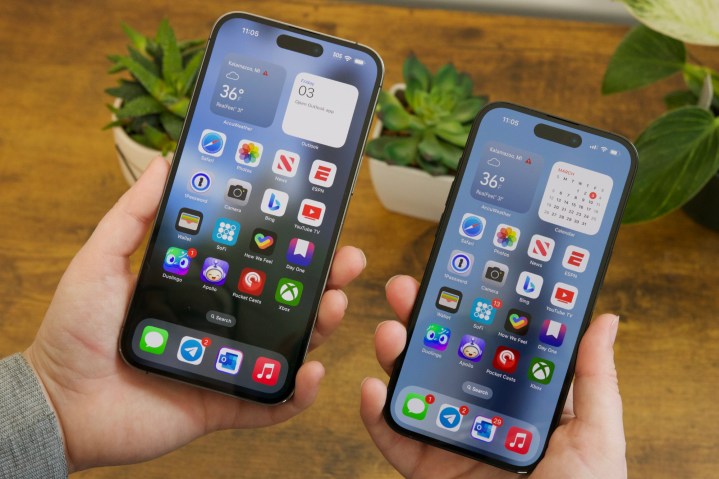 Someone holding an iPhone 14 Pro Max and iPhone 14 Pro next to each other.