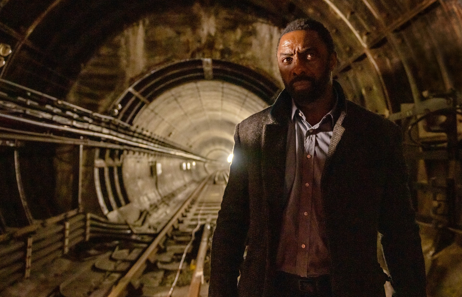 Um homem está em um túnel do metrô em Luther: The Fallen Sun.