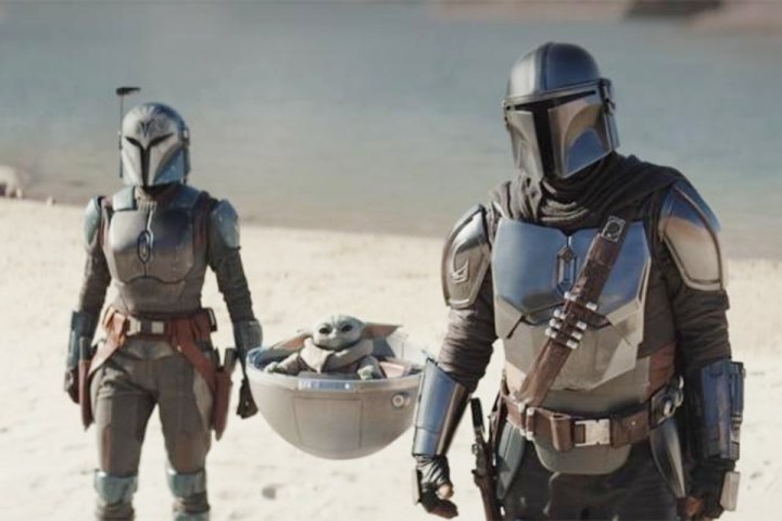 Din, Grogu, and the Armoror stand in the desert in The Mandalorian.