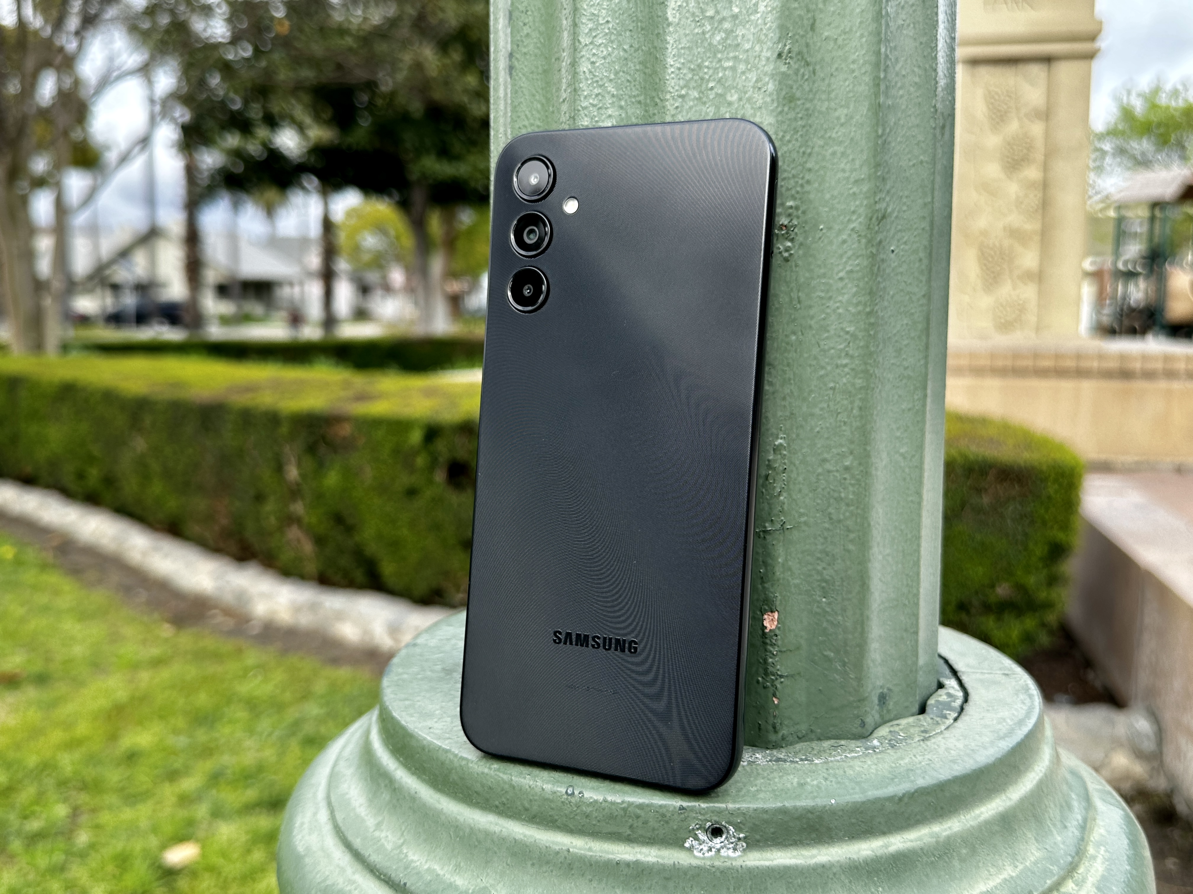 Samsung Galaxy A14 5G leaning against lamppost