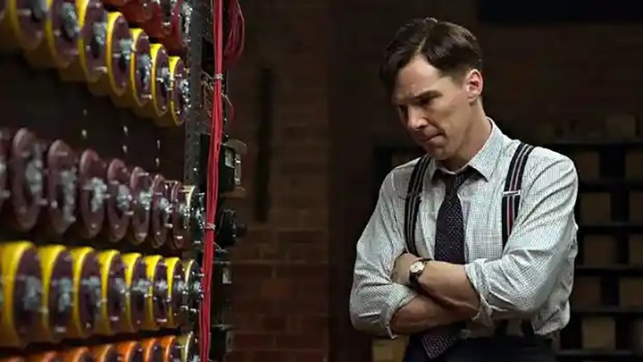 Benedict Cumberatch looks at a row of codes on the wall in a scene from The Imitation Game.
