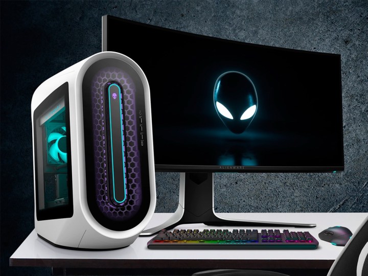 An Alienware Aurora R15 gaming desktop alongside a gaming monitor on a desk.