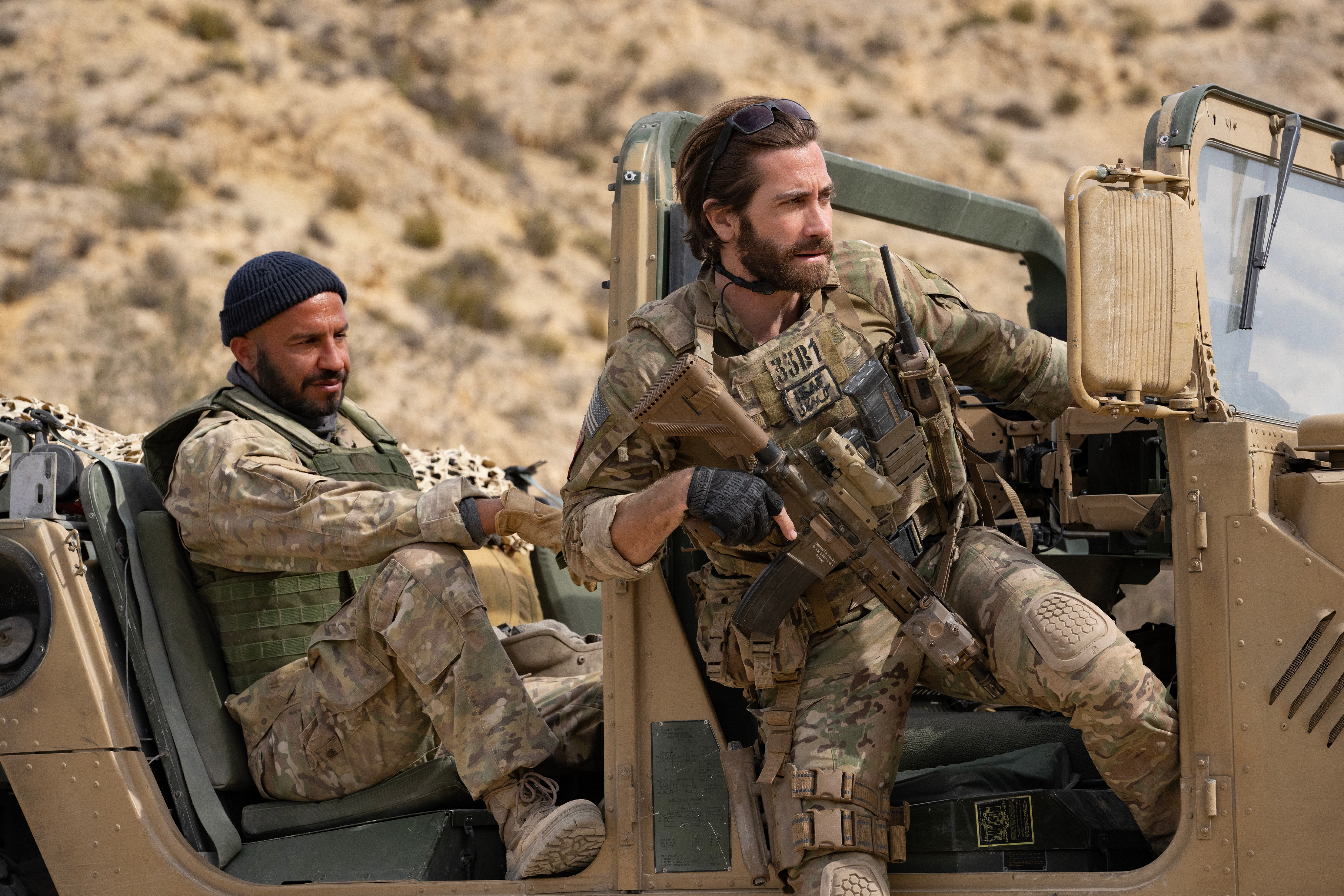 Dar Salim and Jake Gyllenhaal sit in a military Humvee together in The Covenant.