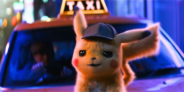 Detective Pikachu stands in front of a taxi cab at night.