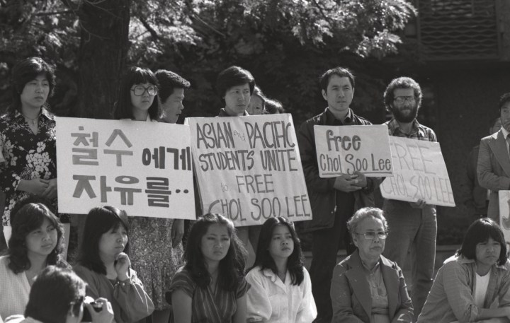 Women hold signs outside of a courthouse in Free Chol Su Lee.