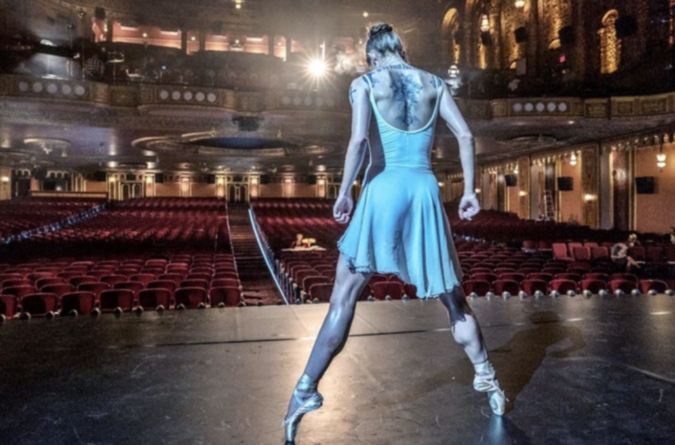 Uma bailarina se levanta e se flexiona no palco em John Wick 3.