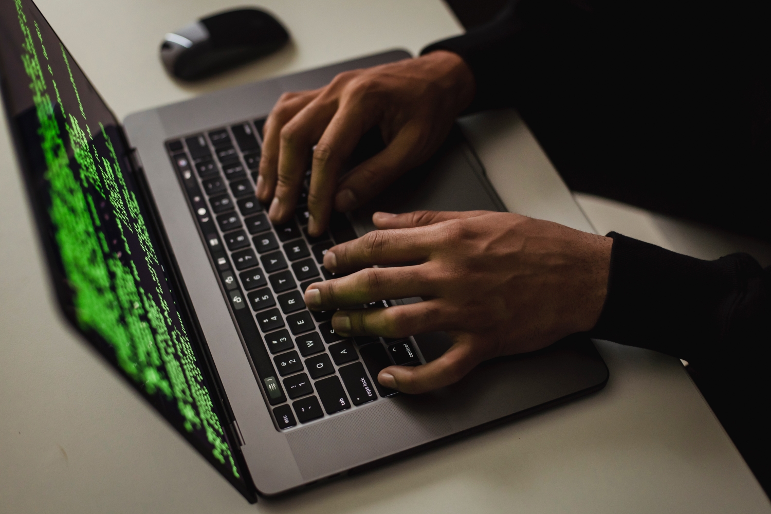 Uma pessoa usando um laptop com um conjunto de códigos visto na tela.