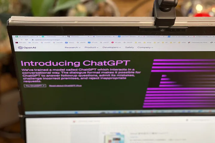 پست وبلاگ OpenAI ChatGPT روی یک مانیتور کامپیوتر باز است و از زاویه بالا گرفته شده است.