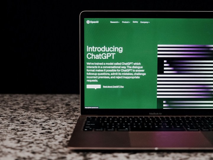 El sitio web de ChatGPT en la pantalla de una computadora portátil mientras la computadora portátil se sienta en un mostrador frente a un fondo negro.