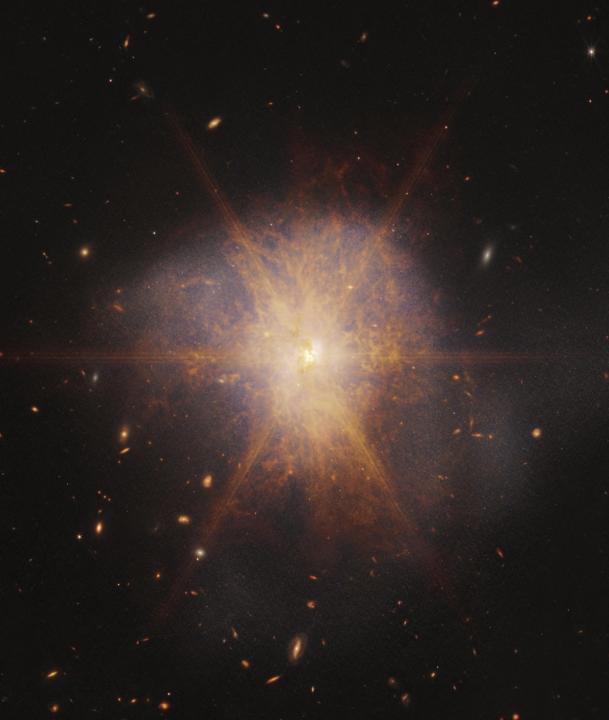 Brillando como un faro brillante en medio de un mar de galaxias, Arp 220 ilumina el cielo nocturno en esta vista desde el Telescopio Espacial James Webb de la NASA. En realidad, dos galaxias espirales en proceso de fusión, Arp 220 brilla más brillante en luz infrarroja, lo que la convierte en un objetivo ideal para Webb. Es una galaxia infrarroja ultraluminosa (ULIRG) con una luminosidad de más de un billón de soles. En comparación, nuestra galaxia, la Vía Láctea, tiene una luminosidad mucho más modesta de unos diez mil millones de soles.