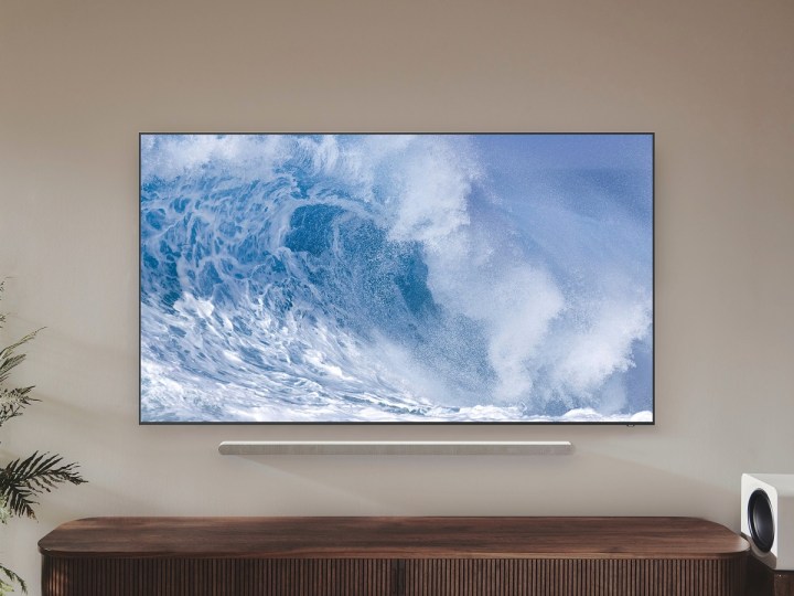 The Samsung QN700B QLED 8K TV with a wave on the screen, while mounted to a wall.