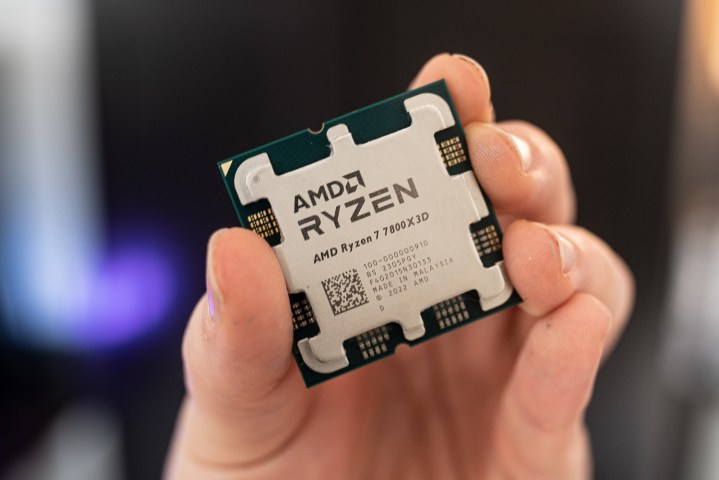 AMD Ryzen 7 7800X3D held between fingertips.
