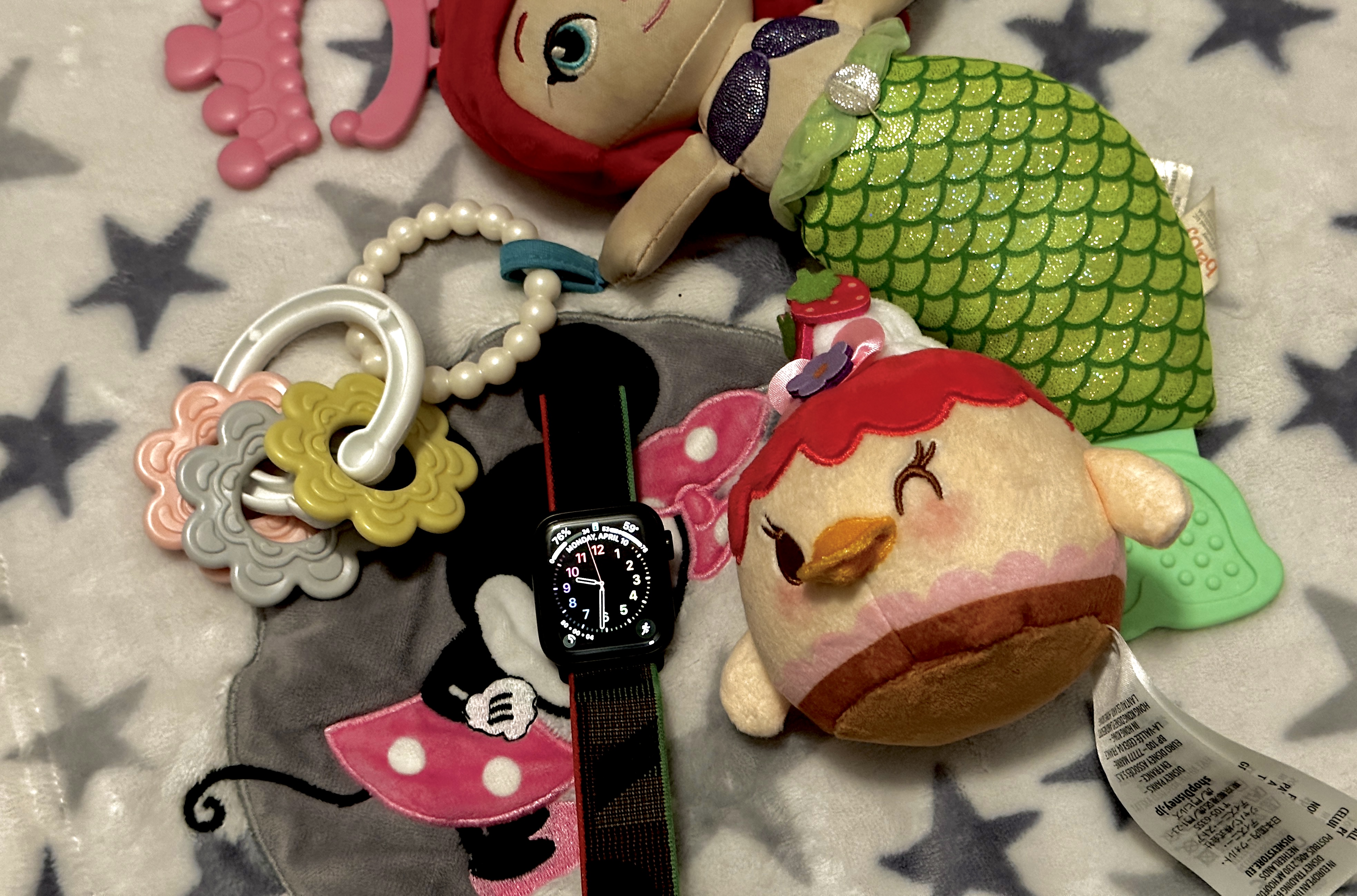Apple Watch laying among some children's toys on a blanket