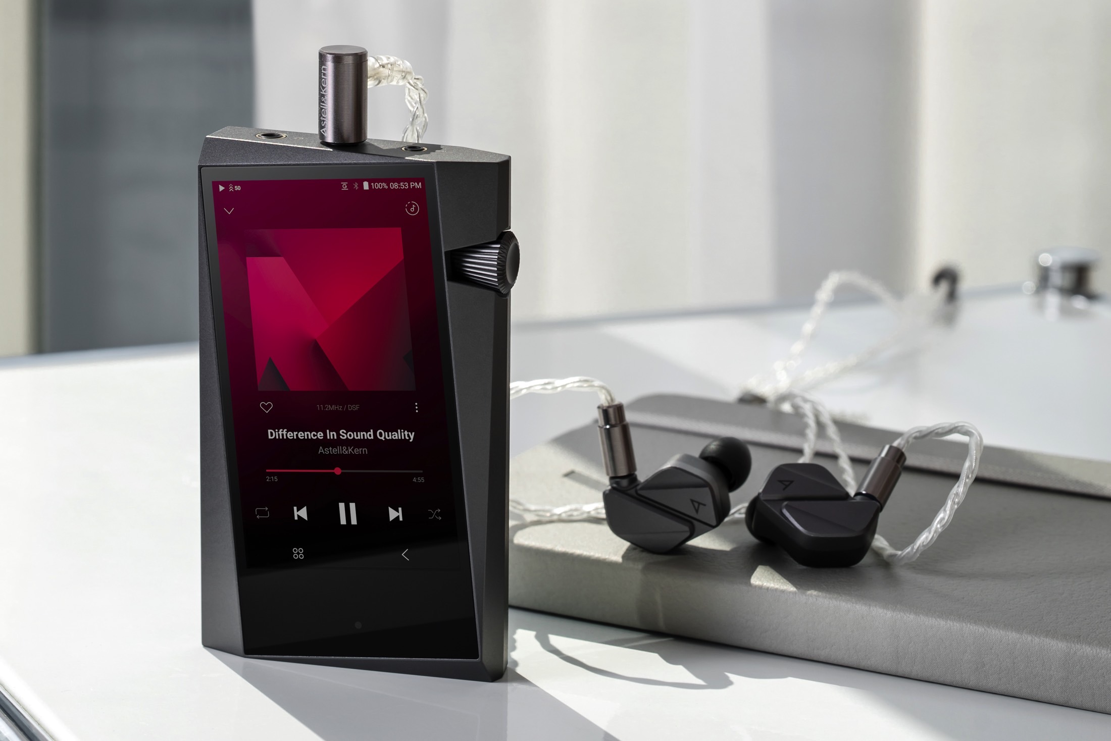 Astell&Kern SR35 digital audio player with earbuds.