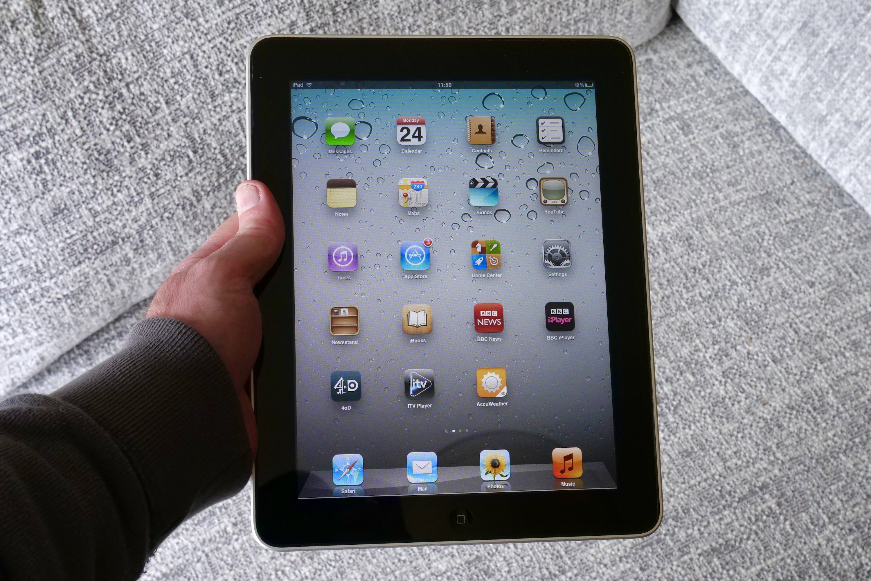 Uma pessoa segurando o iPad original, mostrando a tela.