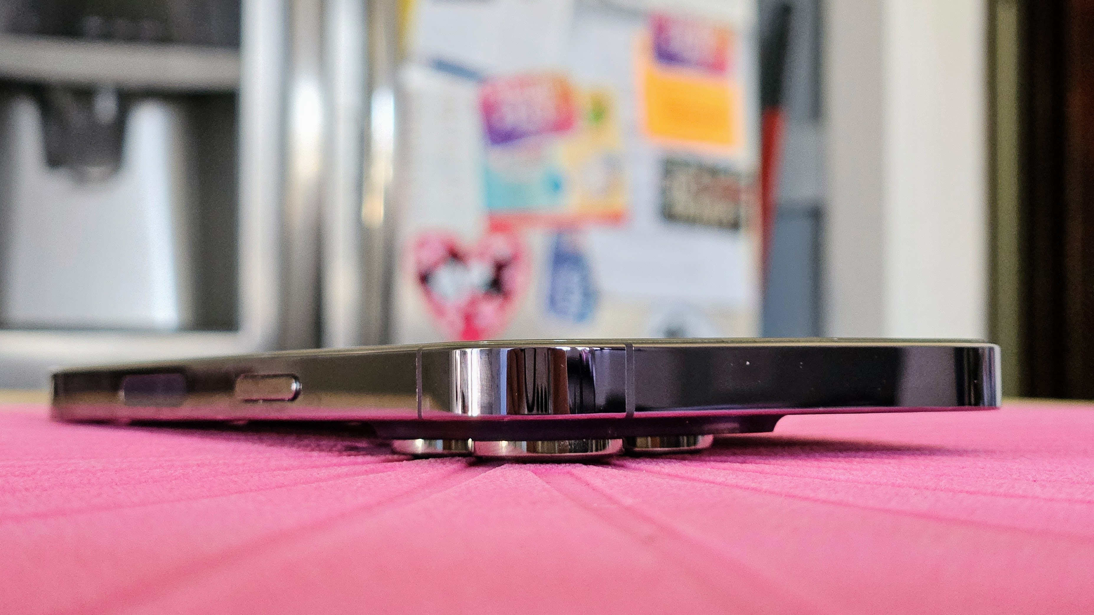 Um iPhone 14 Pro Deep Purple em uma mesa mostrando que a saliência da câmera torna impossível deitar na horizontal