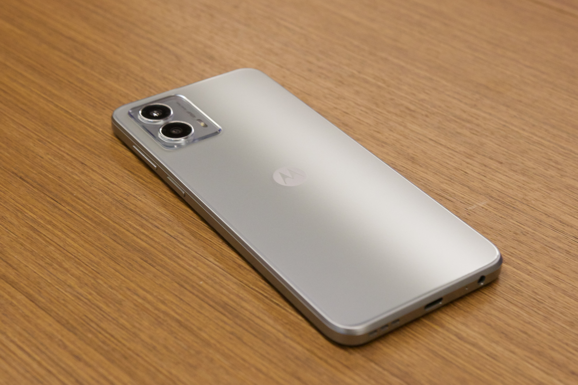 The Moto G 5G 2023, in silver, lying on a desk.