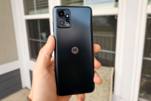 A hand holding a black Moto G Power 5G showing off its cameras and back.