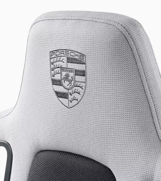 Um close-up do brasão da Porsche em uma cadeira de jogos.