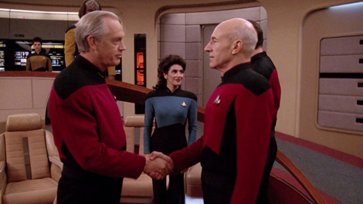 Picard shakes the hand of an old man in Star Trek: The Next Generation.