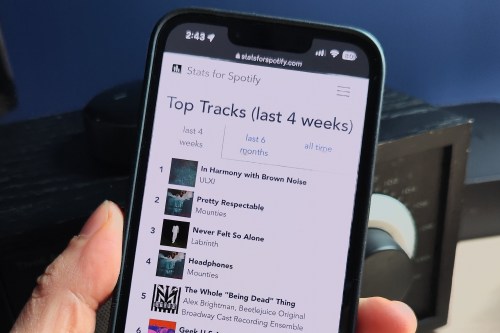 An iPhone with the Stats for Spotify screen on it being held in a hand.