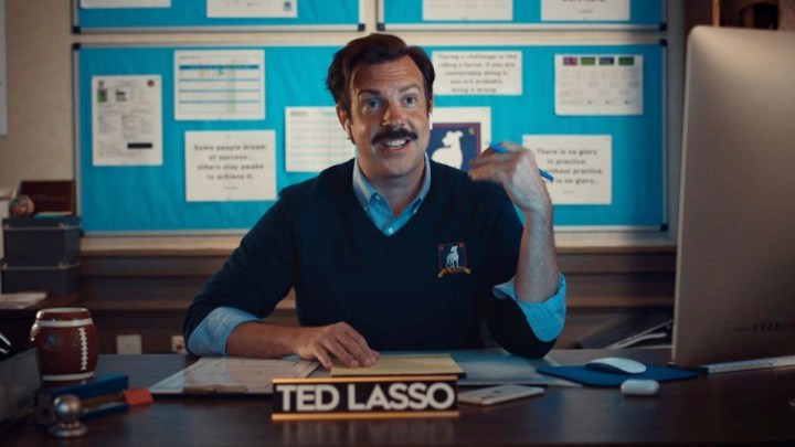 Ted sits at his desk in Ted Lasso.