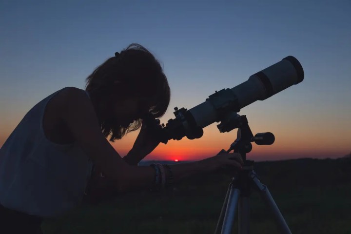 a woman peering into a telescope