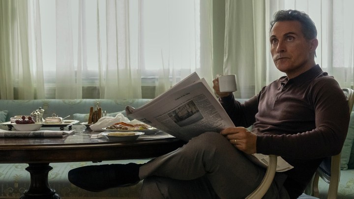 Hal, Netflix'teki The Diplomat'tan bir sahnede oturup gazete okuyor.