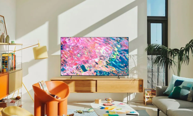The Samsung Q60B QLED Smart TV sits on a media cabinet in a living room.