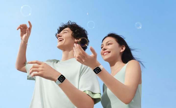 Two people wearing the Amazfit GTS 4 Mini smartwatch.