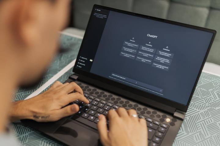 एक व्यक्ति लैपटॉप पर टाइप कर रहा है जो चैटजीपीटी जनरेटिव एआई वेबसाइट दिखा रहा है।