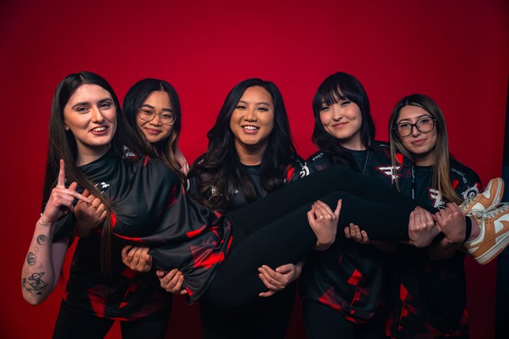 Una foto del equipo de los cinco miembros del primer equipo femenino de esports de FaZe Clan. Cuatro de los miembros están sosteniendo al quinto miembro y todos sonríen.