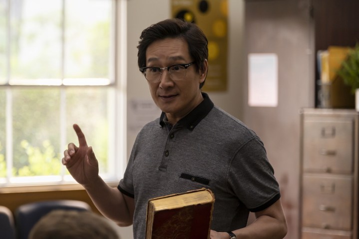 Ke Huy Quan holds a book in American Born Chinese.