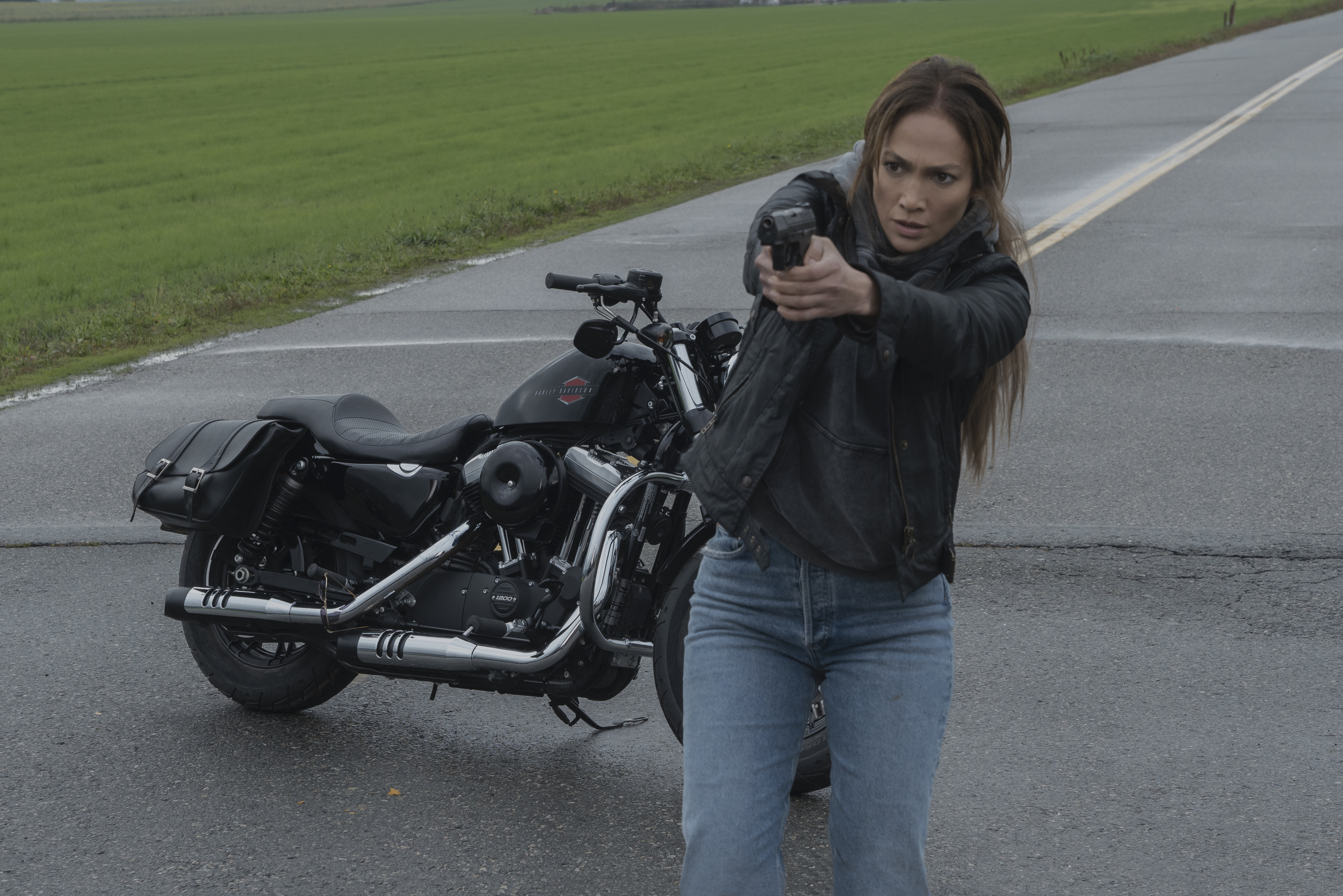 Jennifer Lopez aponta uma arma na frente de sua motocicleta em The Mother.