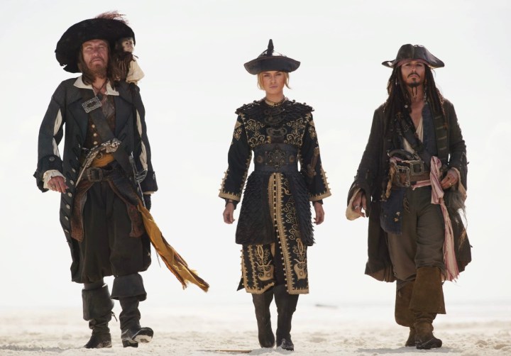 Tres piratas caminan juntos al unísono en At World's End.