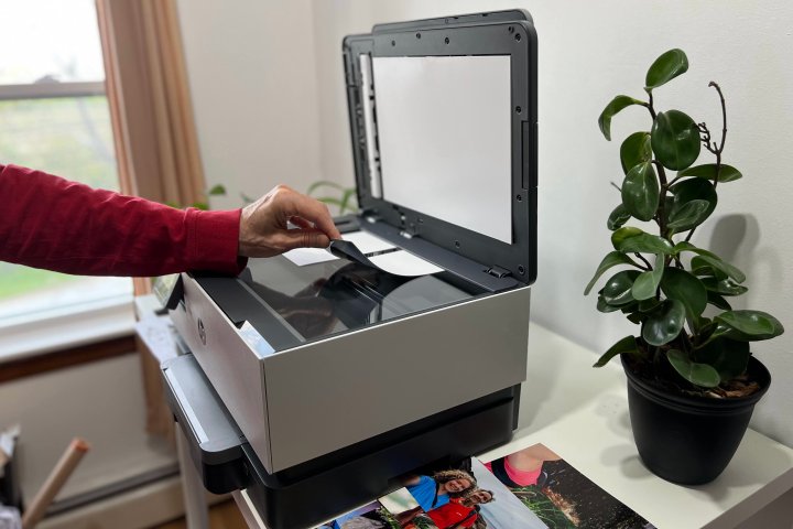 Placing photos on the HP OfficeJet Pro 9015e's flatbed scanner glass.